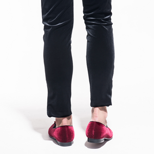 Burgundy velvet loafers with a casual black jean, from the rear.